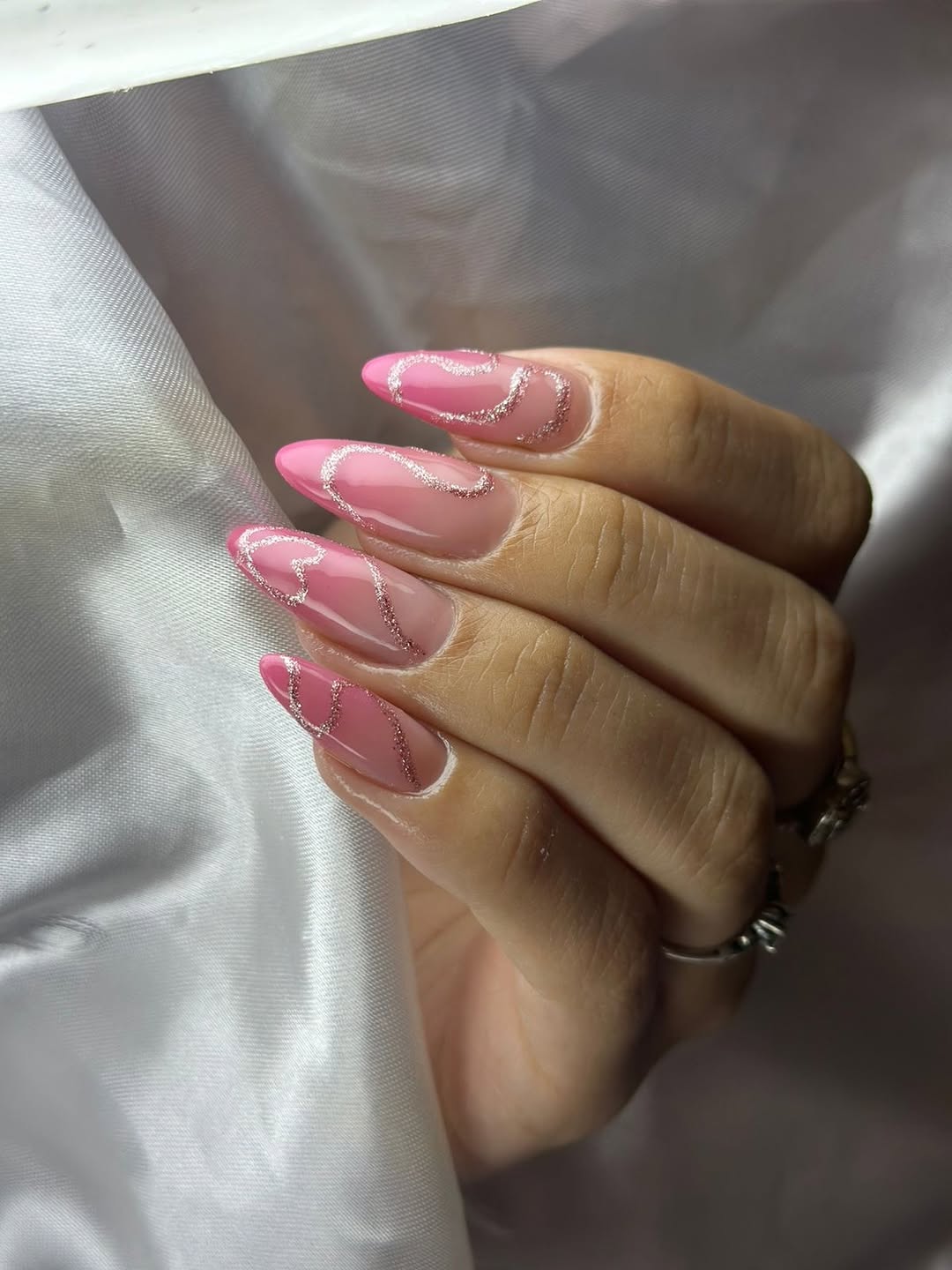 Unhas rosa nude com design de glitter ondulado